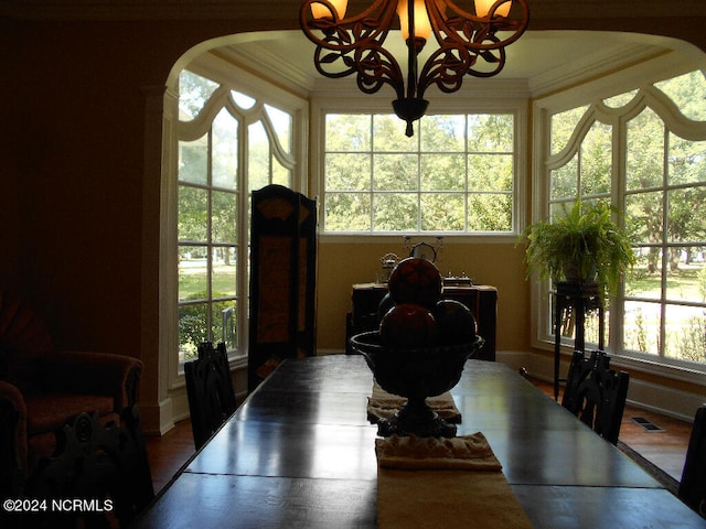 dining area featuring a wealth of natural light, crown molding, a notable chandelier, and wood-type flooring