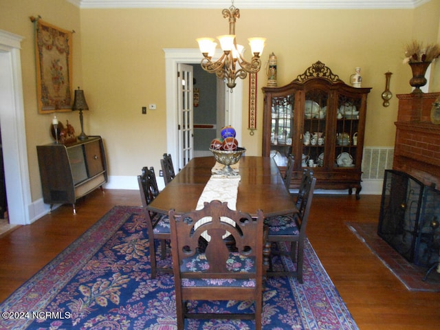 dining room with an inviting chandelier, crown molding, and dark hardwood / wood-style floors