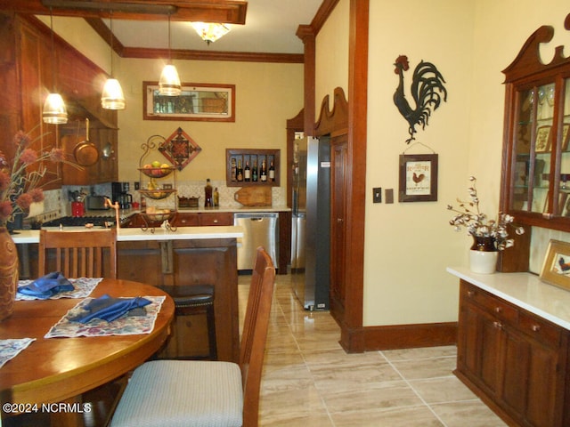 kitchen with kitchen peninsula, light tile patterned floors, appliances with stainless steel finishes, crown molding, and decorative light fixtures