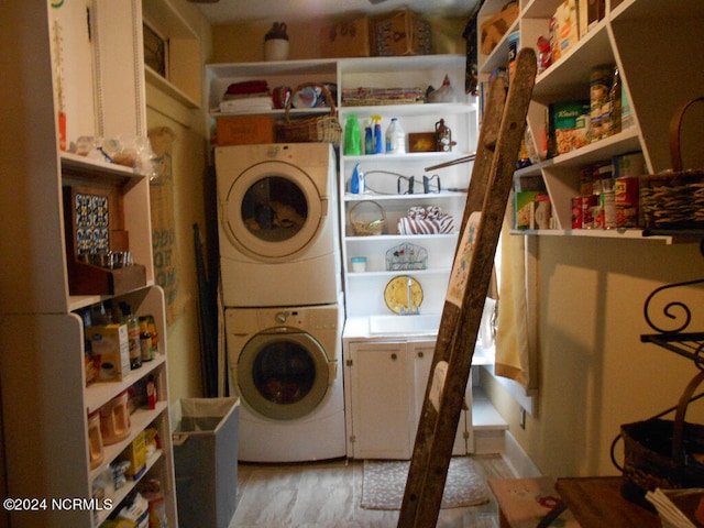 clothes washing area with stacked washer / dryer and light hardwood / wood-style floors