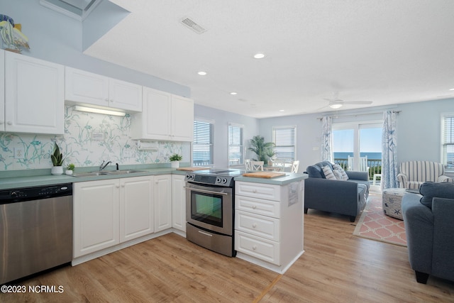 kitchen with sink, light hardwood / wood-style flooring, appliances with stainless steel finishes, white cabinets, and kitchen peninsula