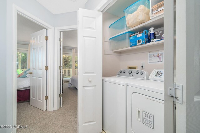 laundry room with washing machine and dryer and light colored carpet