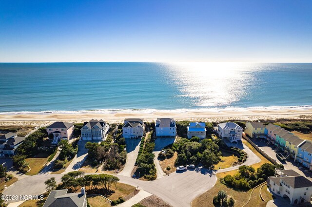 birds eye view of property featuring a water view and a beach view