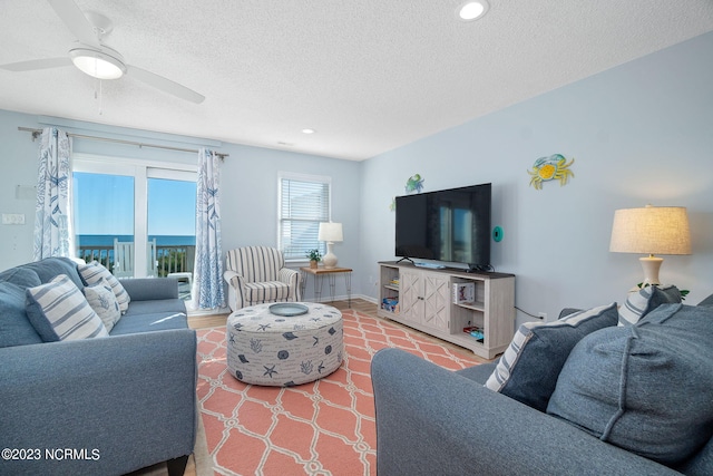 living room featuring a textured ceiling and ceiling fan