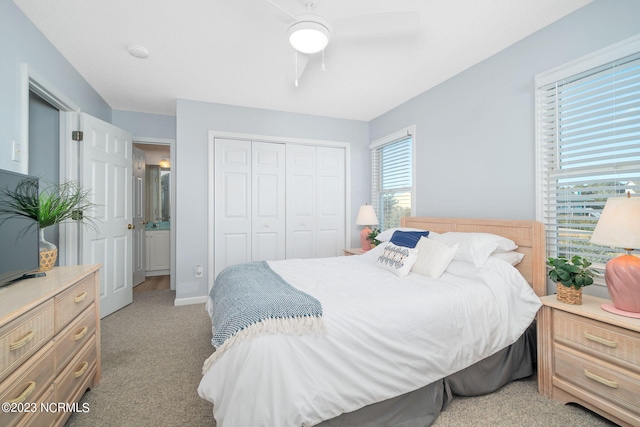 bedroom with light carpet, multiple windows, a closet, and ceiling fan