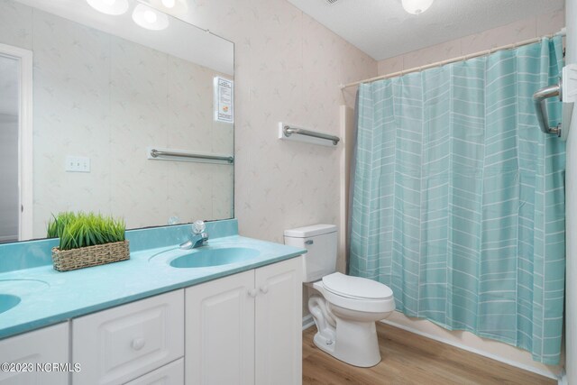 full bathroom featuring a textured ceiling, toilet, vanity, shower / tub combo with curtain, and hardwood / wood-style flooring