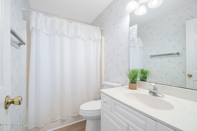 full bathroom with vanity, toilet, shower / bath combo with shower curtain, and hardwood / wood-style floors