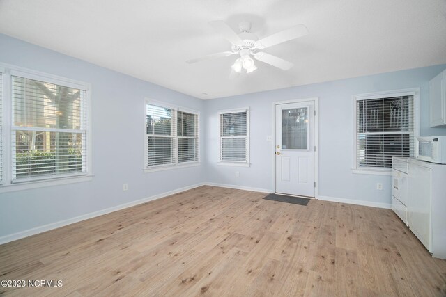 interior space featuring ceiling fan, washer / clothes dryer, and light wood-type flooring