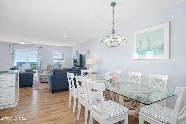 dining area with ceiling fan with notable chandelier and light wood-type flooring