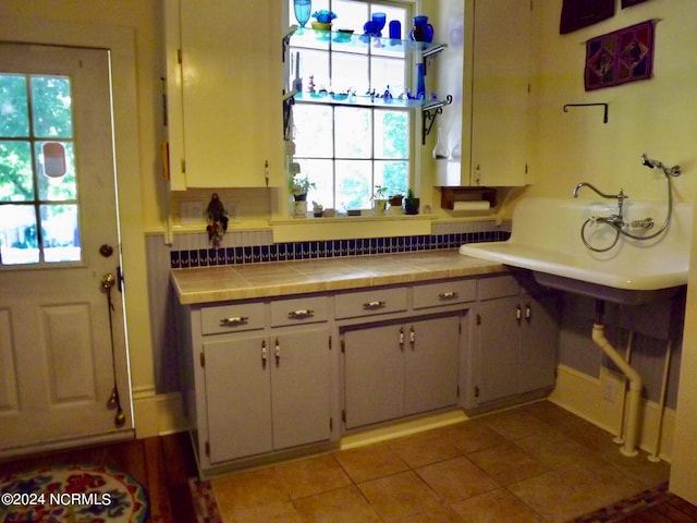 1222 National Ave, New Bern, NC 28560 - kitchen with plenty of natural light, light tile patterned floors, and tile counters