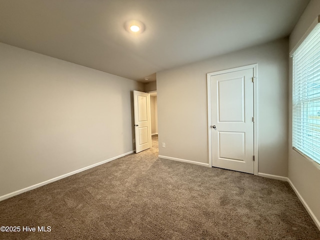 unfurnished bedroom with carpet floors and baseboards