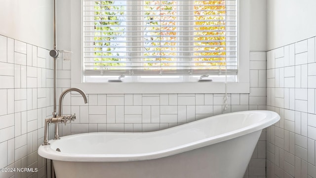 bathroom with a freestanding bath and tile walls