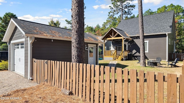 view of front facade with a deck, a fire pit, and a garage