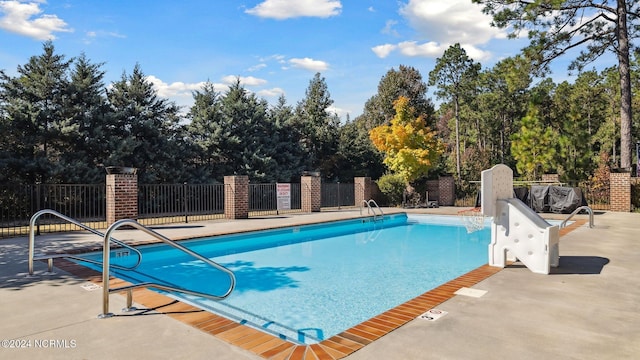 community pool featuring a patio and fence