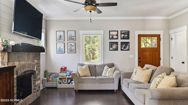 living room with dark wood-type flooring, ceiling fan, ornamental molding, and a fireplace