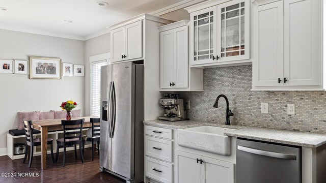 kitchen with light stone counters, dark hardwood / wood-style flooring, white cabinetry, sink, and stainless steel appliances