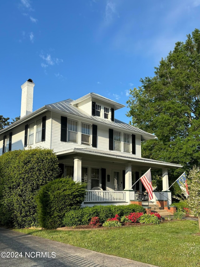 view of front of property with covered porch and a front yard