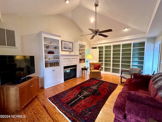 living room featuring ceiling fan, lofted ceiling, built in features, and light hardwood / wood-style floors