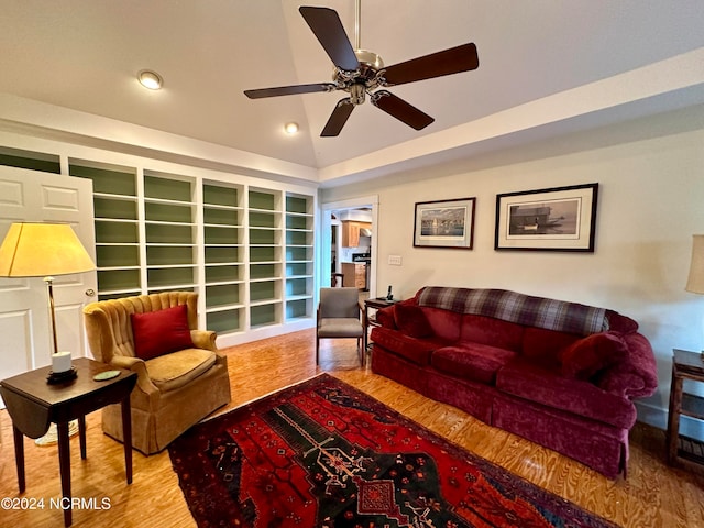 living room with ceiling fan, hardwood / wood-style flooring, and vaulted ceiling