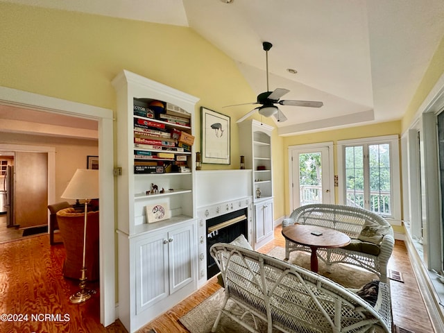 living room with ceiling fan, hardwood / wood-style flooring, and lofted ceiling