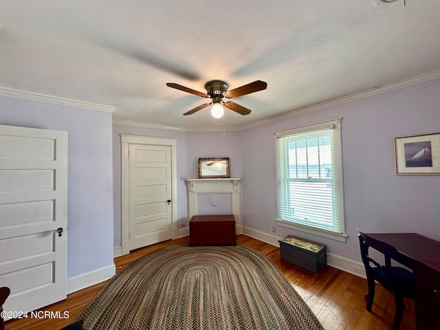 sitting room featuring ceiling fan, crown molding, and dark wood-type flooring