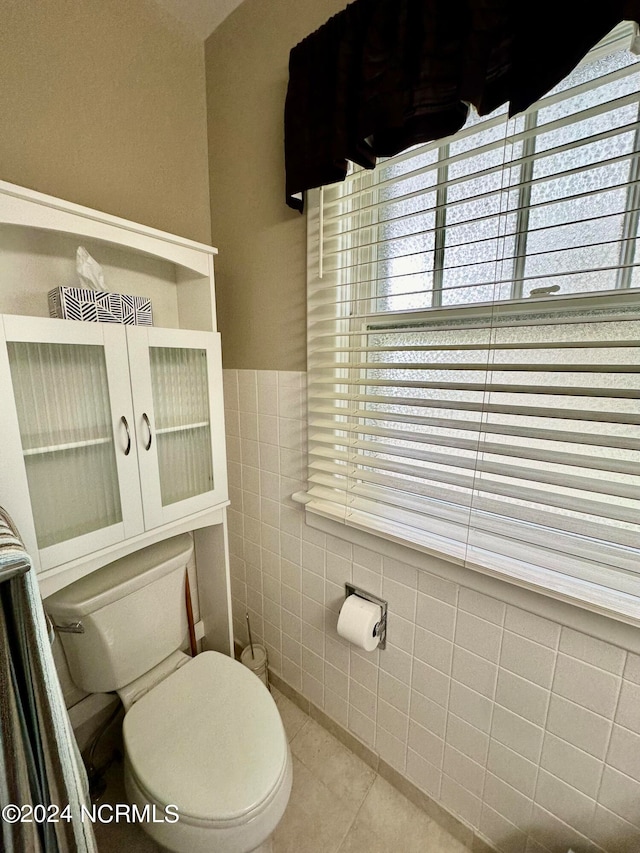 bathroom with tile walls, toilet, and tile patterned floors