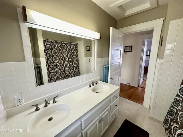 207 W Eden St, Edenton, NC 27932 - bathroom featuring tile walls, tile patterned flooring, double vanity, and a wainscoted wall