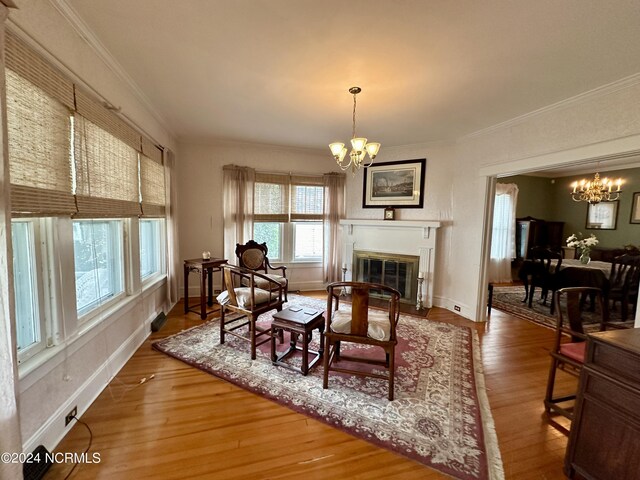 207 W Eden St, Edenton, NC 27932 - dining room with a chandelier, ornamental molding, wood finished floors, baseboards, and a fireplace with flush hearth