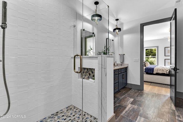 bathroom featuring wood-type flooring, vanity, and a shower with shower door