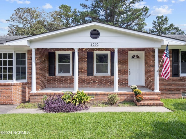 view of front of house featuring a porch and a front lawn