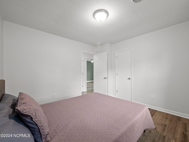 bedroom featuring a textured ceiling and dark wood-type flooring