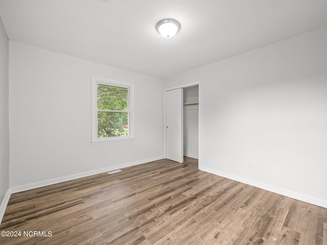 unfurnished bedroom with wood-type flooring and a closet