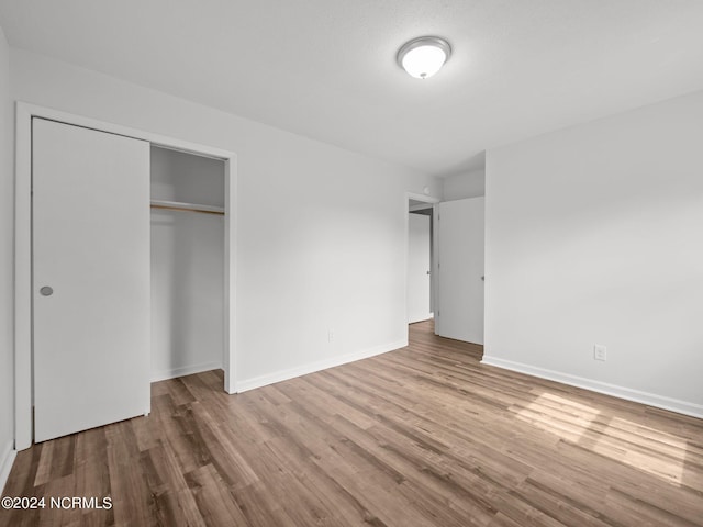 unfurnished bedroom with hardwood / wood-style flooring and a closet