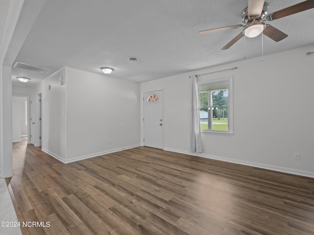 spare room with a textured ceiling, dark hardwood / wood-style flooring, and ceiling fan