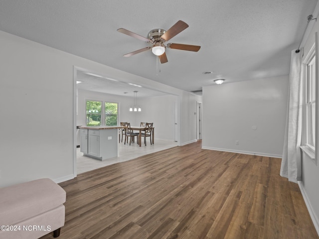 unfurnished living room with ceiling fan, a textured ceiling, and hardwood / wood-style floors