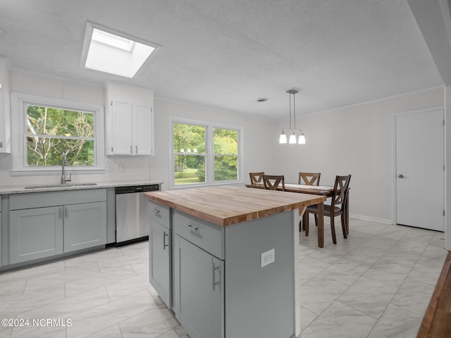 kitchen with pendant lighting, gray cabinets, a center island, sink, and stainless steel dishwasher