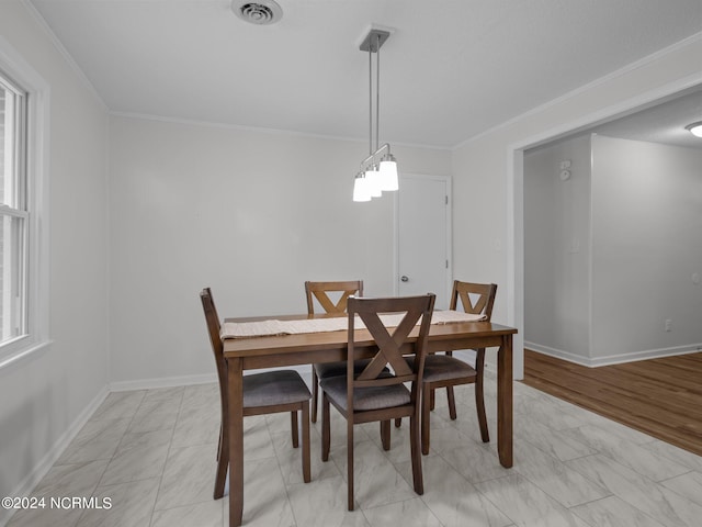 dining room featuring ornamental molding, light hardwood / wood-style flooring, and plenty of natural light