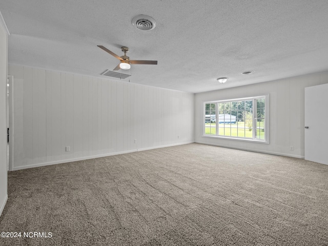 empty room featuring ceiling fan, carpet flooring, and a textured ceiling