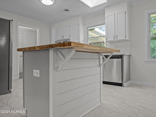 kitchen with stainless steel dishwasher, ornamental molding, butcher block counters, and white cabinets