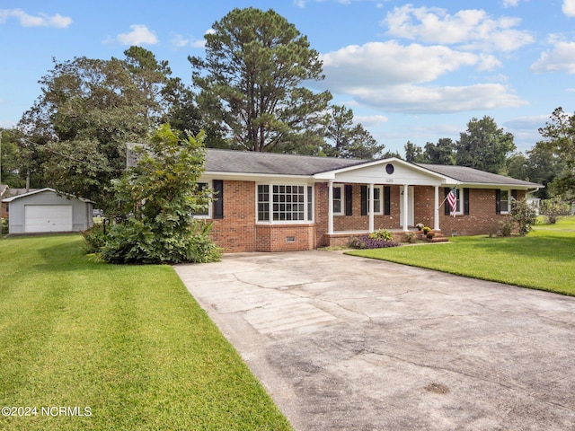 single story home featuring a front yard, an outbuilding, and a garage