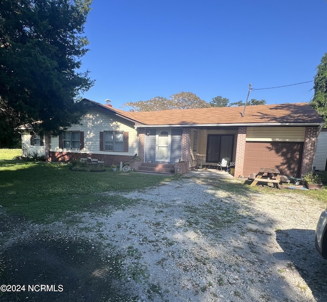 back of house with a garage and a yard