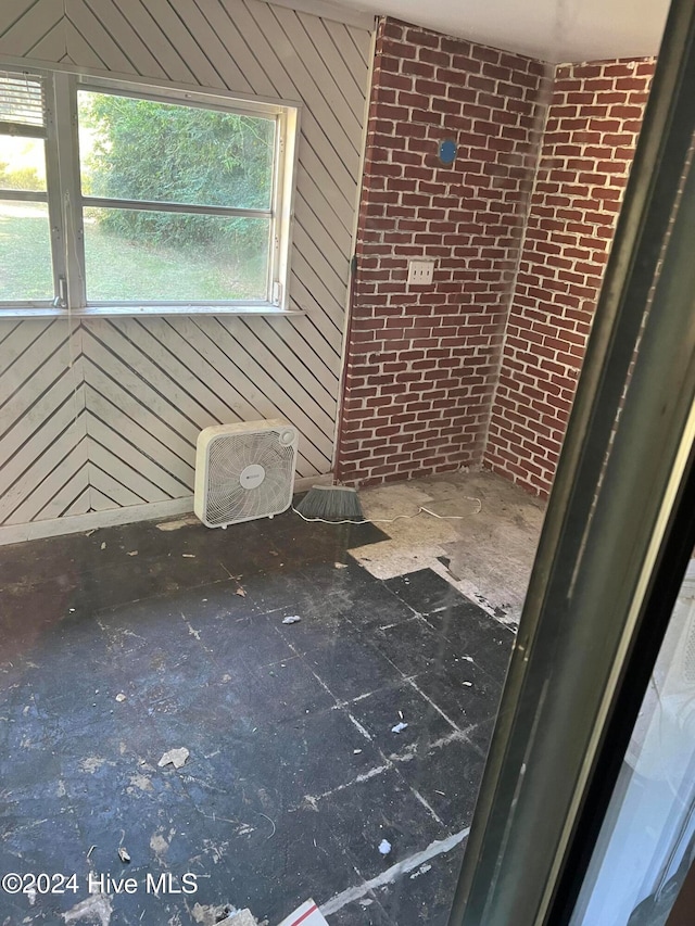 bathroom featuring plenty of natural light, brick wall, and wooden walls