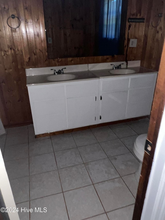 bathroom featuring wood walls, tile patterned flooring, vanity, and toilet