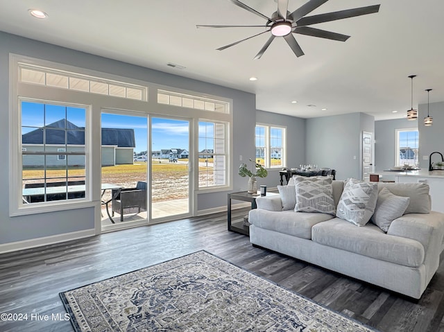 living room featuring a mountain view, dark hardwood / wood-style flooring, ceiling fan, and sink