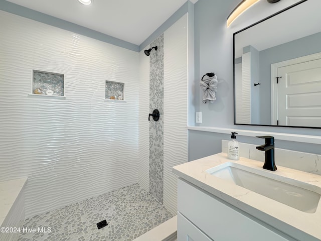 bathroom featuring vanity and tiled shower