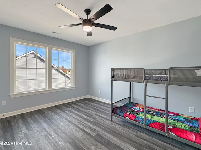 bedroom with dark hardwood / wood-style flooring and ceiling fan