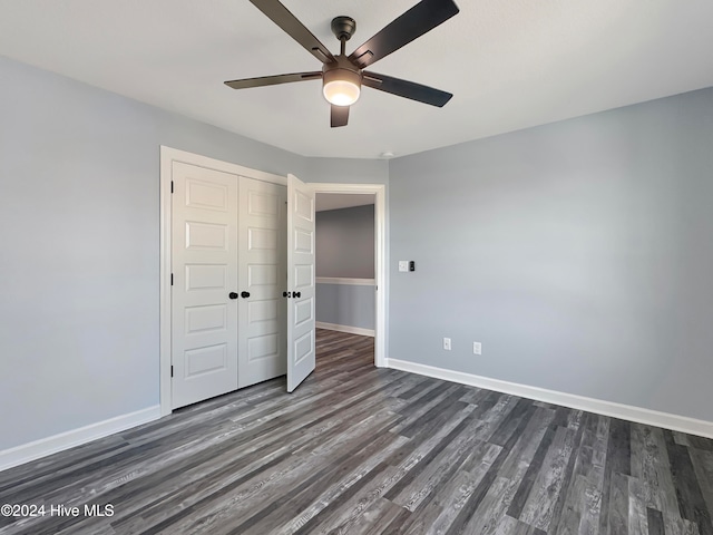 unfurnished bedroom with ceiling fan, dark wood-type flooring, and a closet