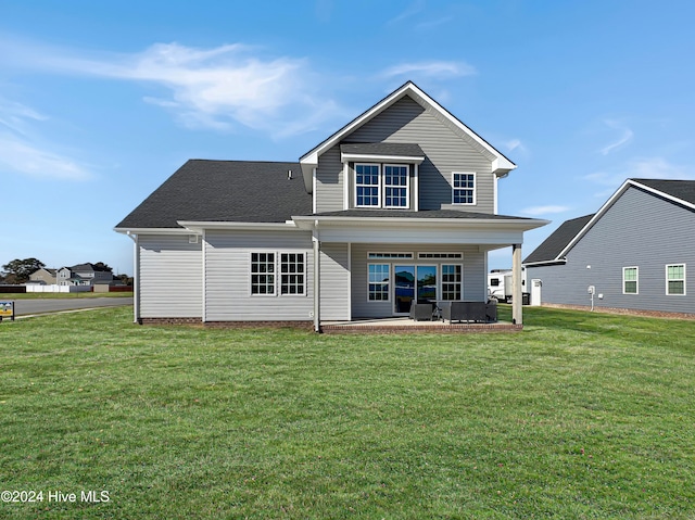 rear view of property featuring a yard and a patio