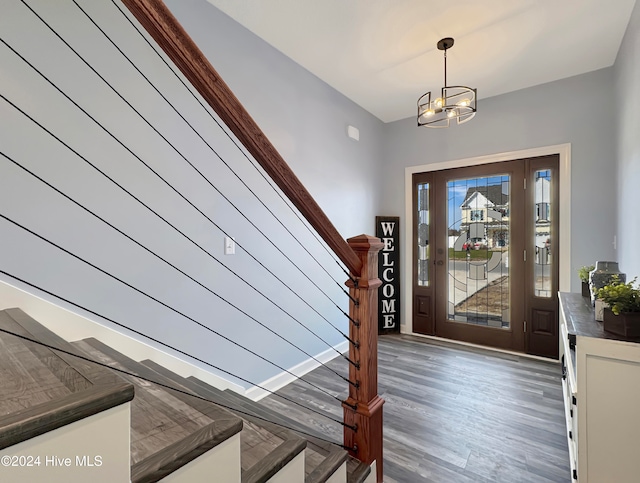 entrance foyer with dark hardwood / wood-style floors and a notable chandelier