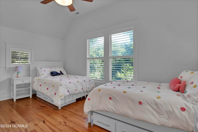 bedroom featuring ceiling fan, light wood-type flooring, and vaulted ceiling